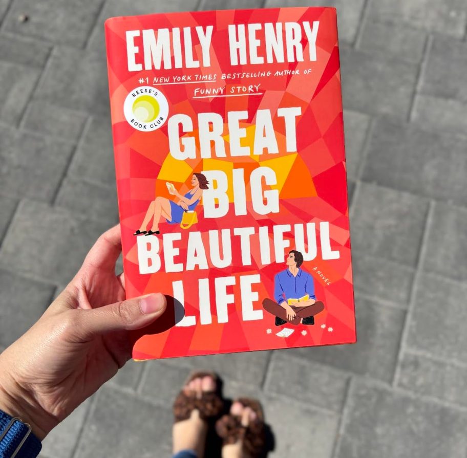 Handholding great big beautiful life book over patio