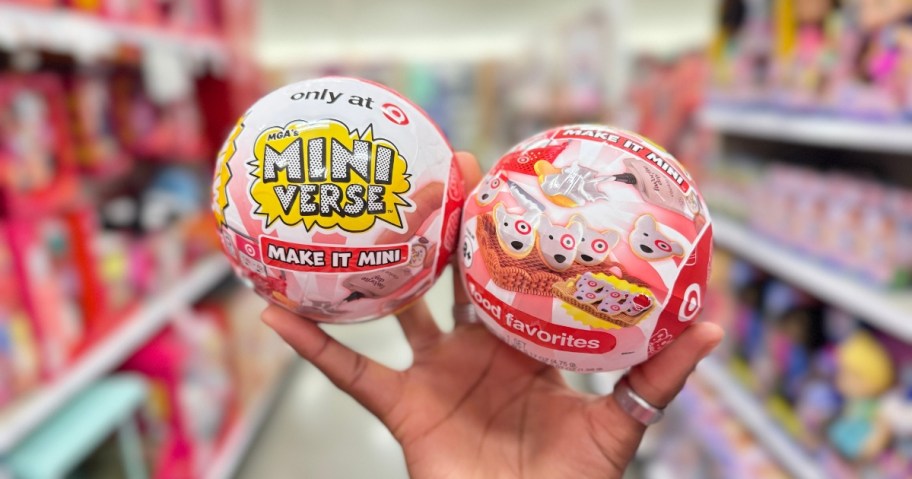hand holding 2 mini verse capsules in a store aisle