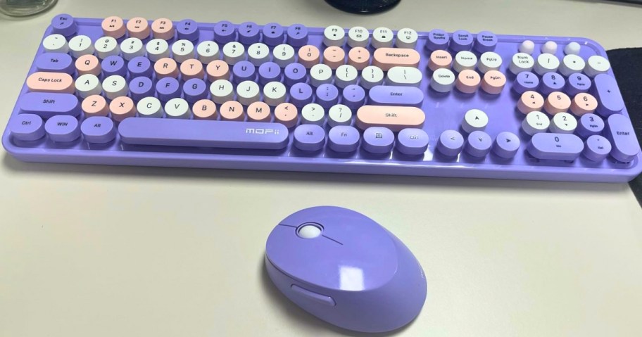 a purple and pink wireless retro keyboard and mouse on a desk