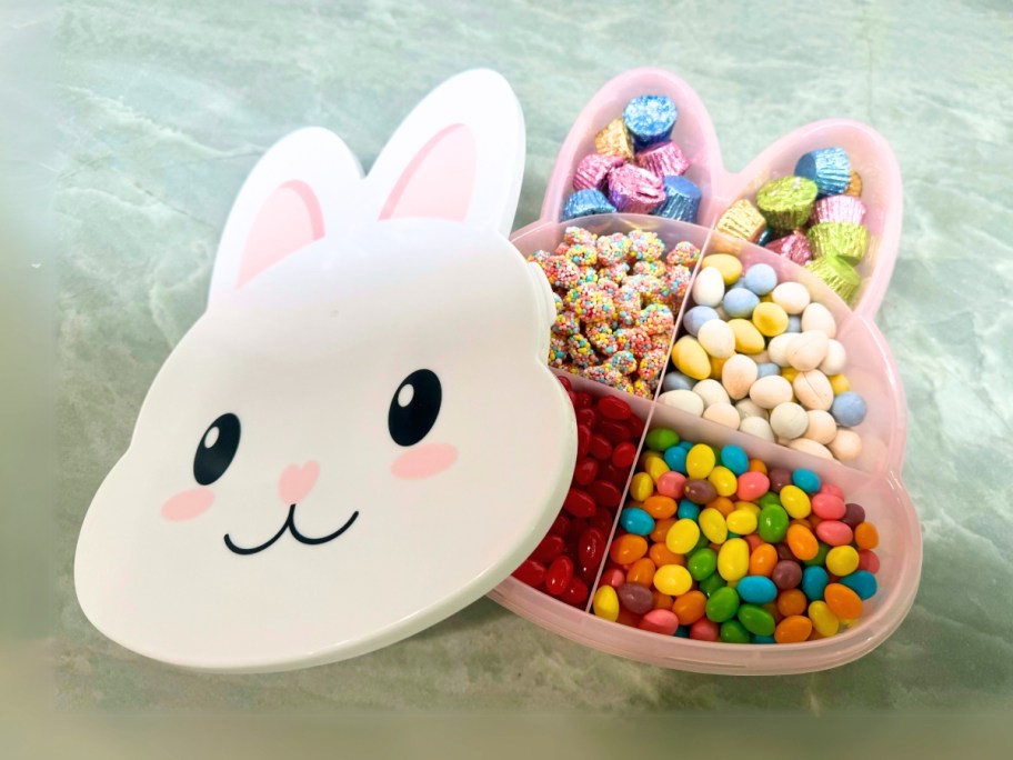 a bunny head shaped snack box with Easter candy in it, the lid is to the side