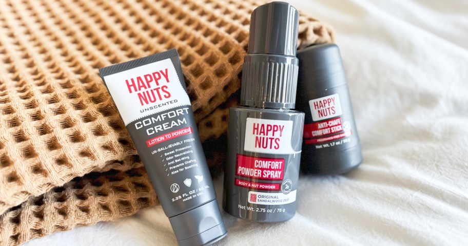 three grey bottles of Happy Nuts products near folded blanket