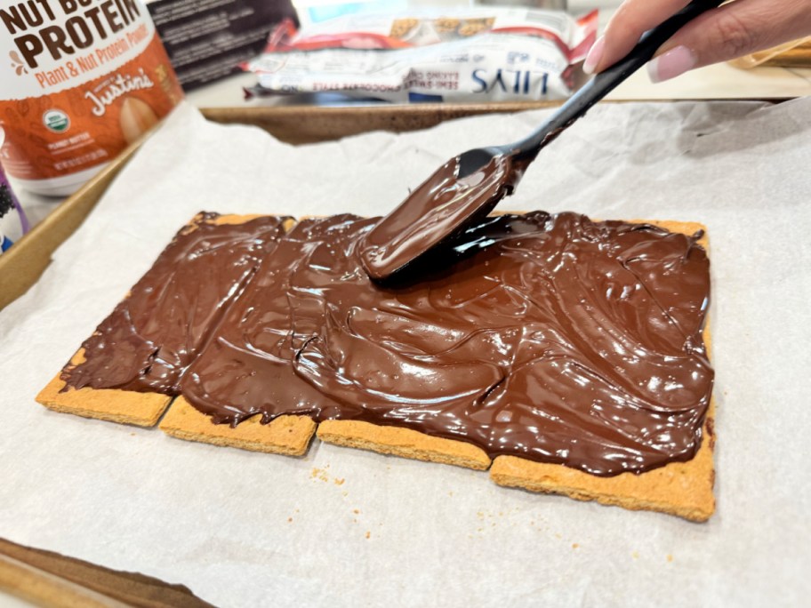 spreading melted chocolate chips onto graham crackers 