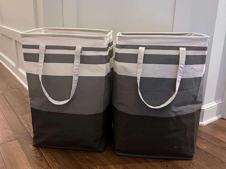 2 large grey and white striped laundry hampers in a hallway