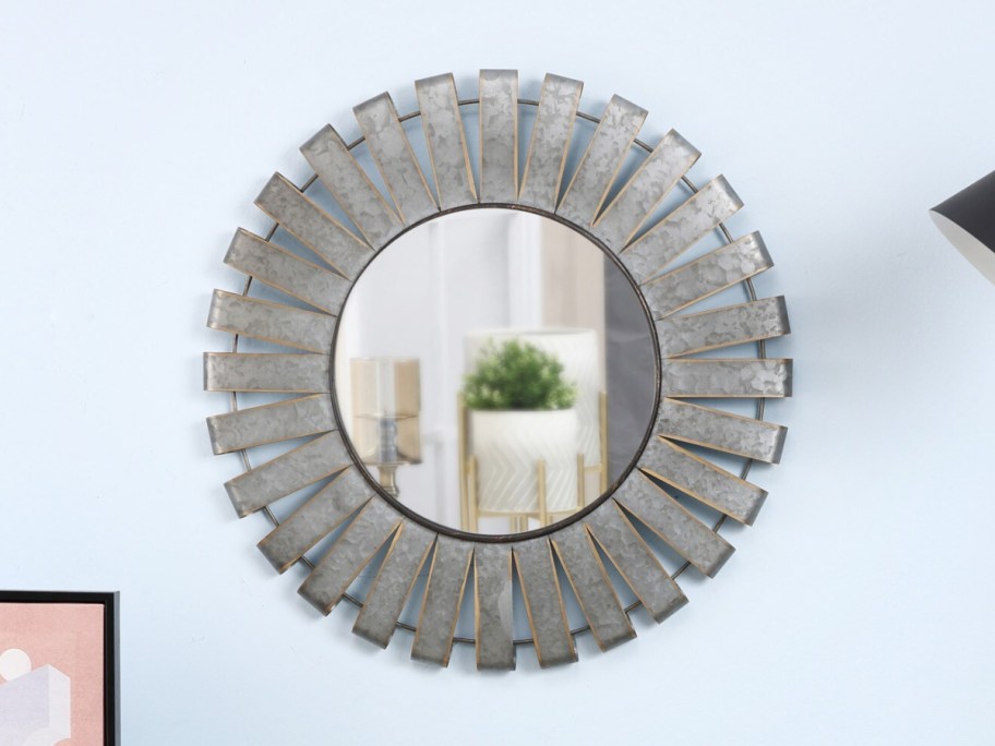 round mirror displayed on a blue wall
