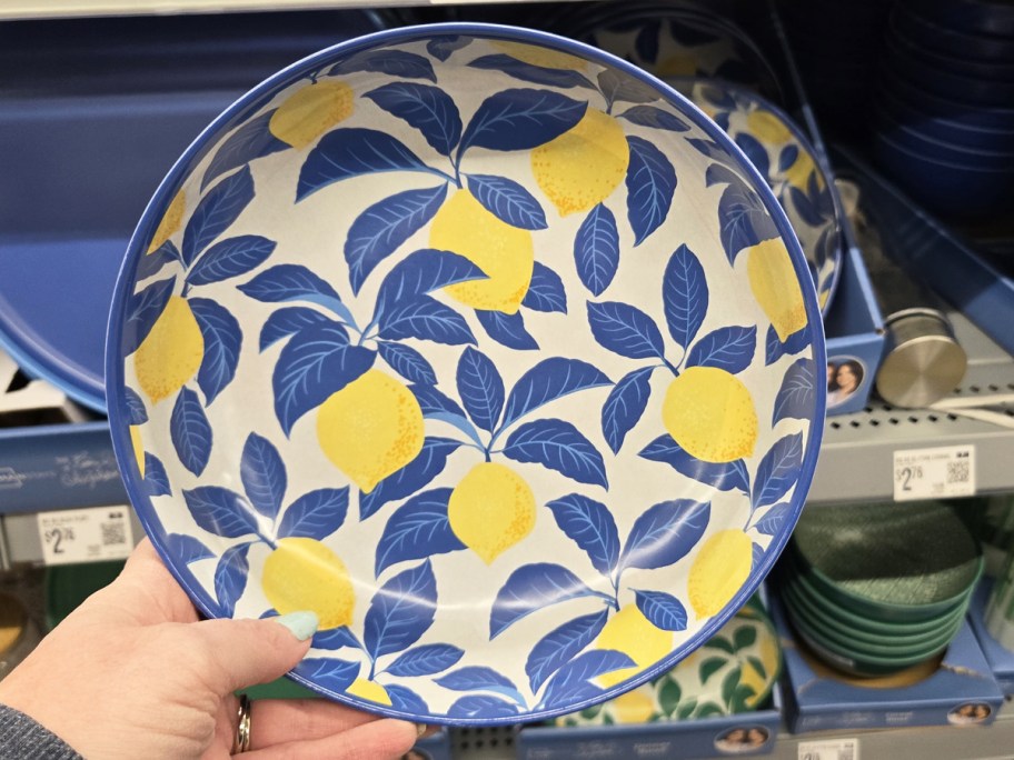 hand holding up a blue and yellow lemon print dinner bowl