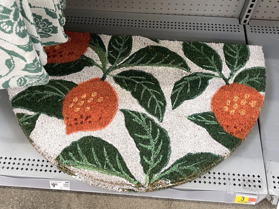 orange-print half-circle door mat on store shelf