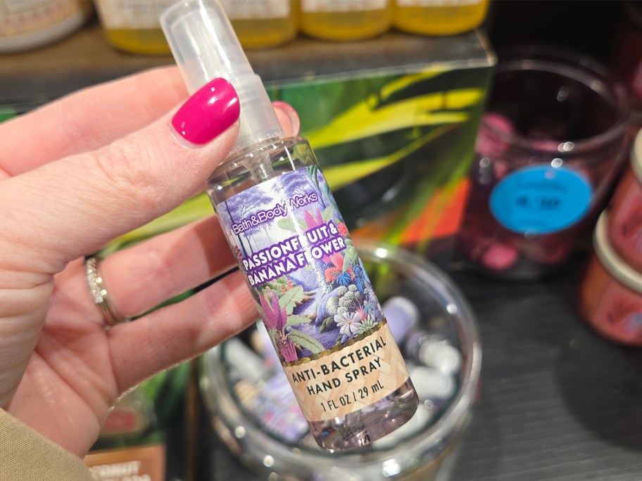 Passionfruit and Banana Flower Hand Sanitizer Spray being held by a woman at a Bath and Body Works Store