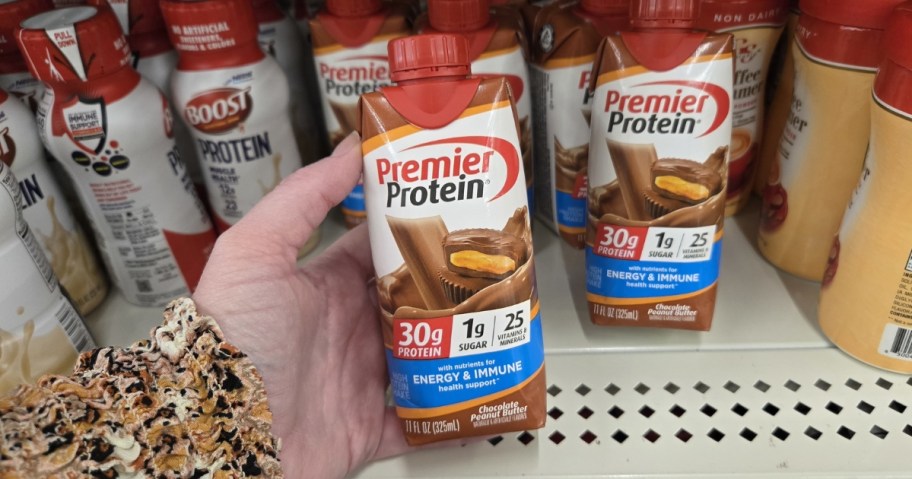 hand holding chocolate peanut butter premier protein shake bottle at dollar tree
