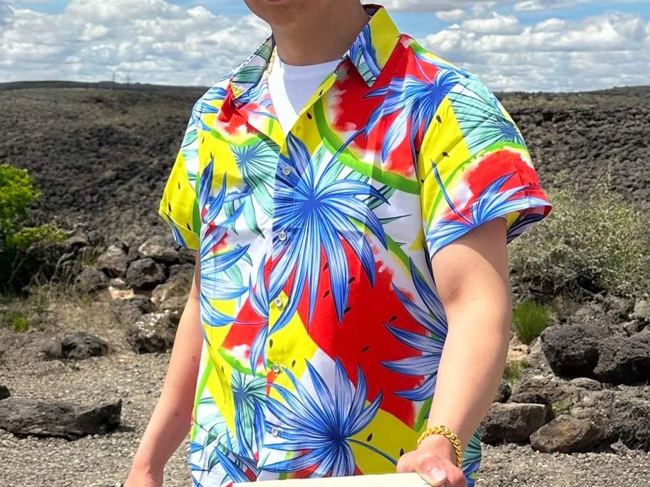 Man wearing a Hawaiian shirt in front of a desert like landscape