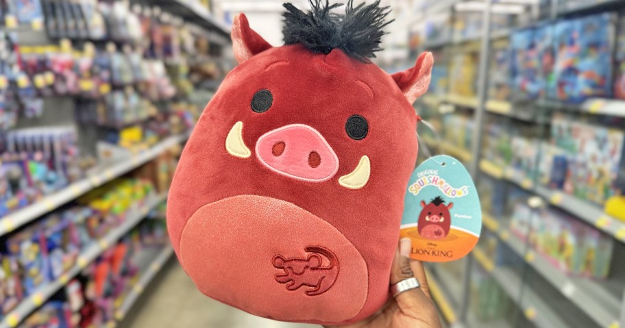 hand holding up a Lion King Pumbaa Squishmallows in store