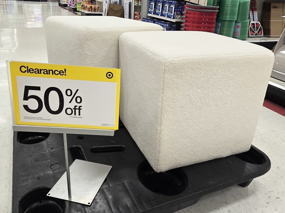 two white cube ottomans on pallet with 50% off clearance sign