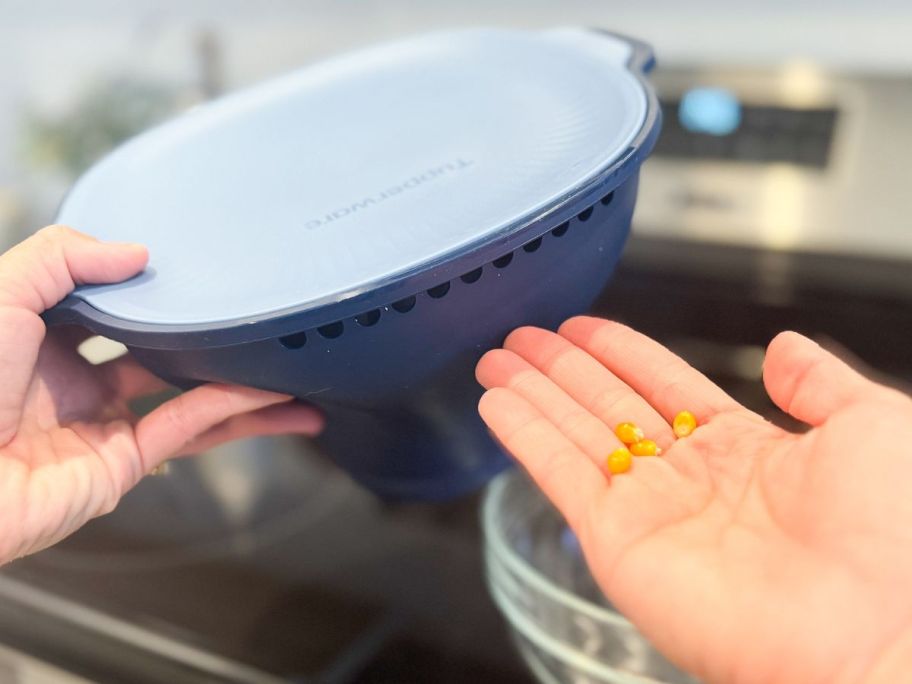 Hand holding kernels removed from a Tupperware popcorn popper