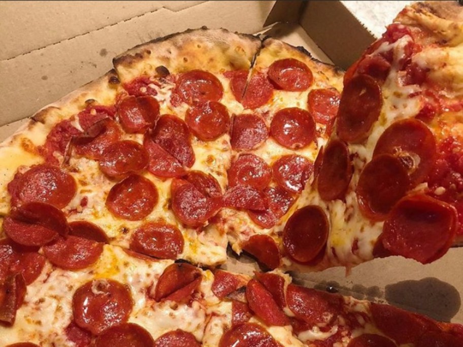 lifting a piece of pizza from a box