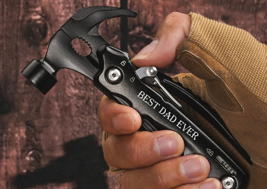 hand holding a multitool hammer with 'best dad ever' printed on side