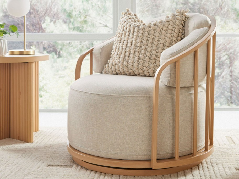 cream better homes and gardens swivel chair with a throw pillow