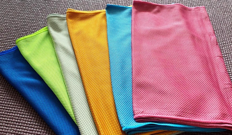 six colorful cooling towels folded on a table
