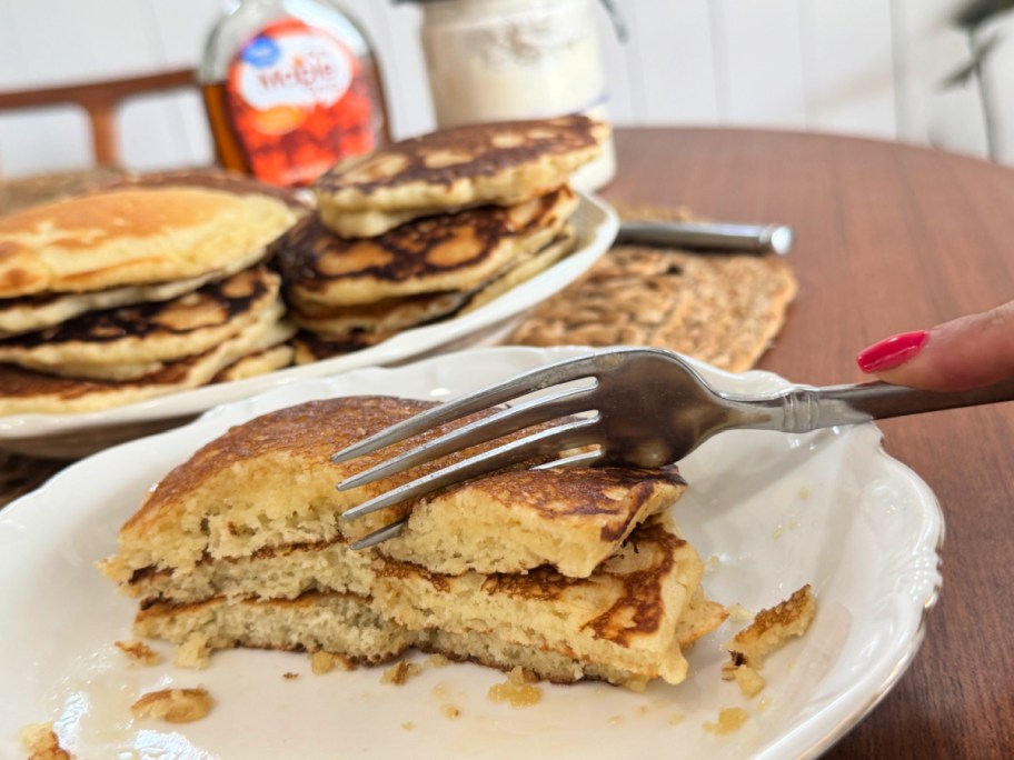 cutting through sourdough pancakes with maple syrup on them 
