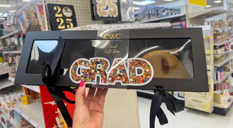 word snack box that says GRAD being held in hand in a store