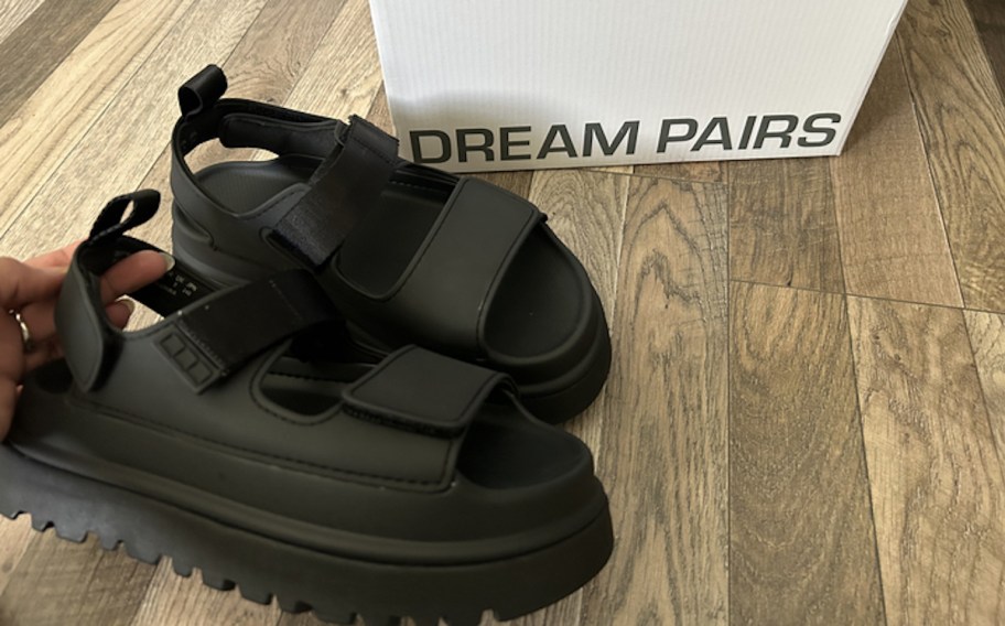 black pair of dream pairs wedge sandals on wood floor with box