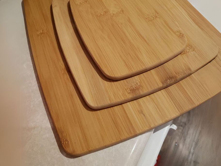 three farberware bamboo cutting board stacked on top of each other on a counter