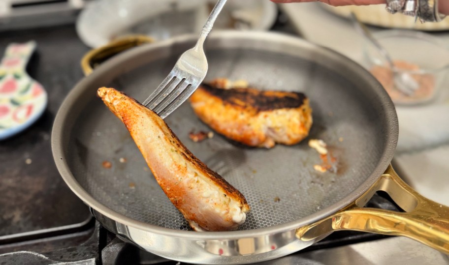 flipping chicken breasts in a frying pan