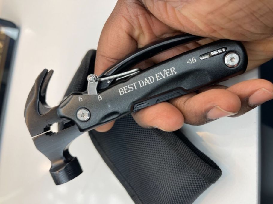 hand holding multi tool hammer with "best dad ever" written on it