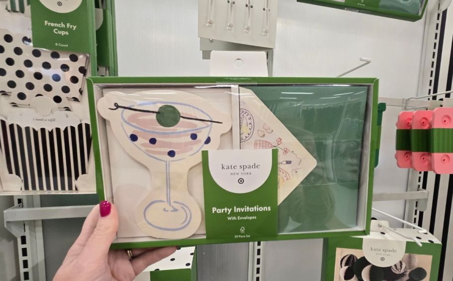 a womans hand holding a box of party invites