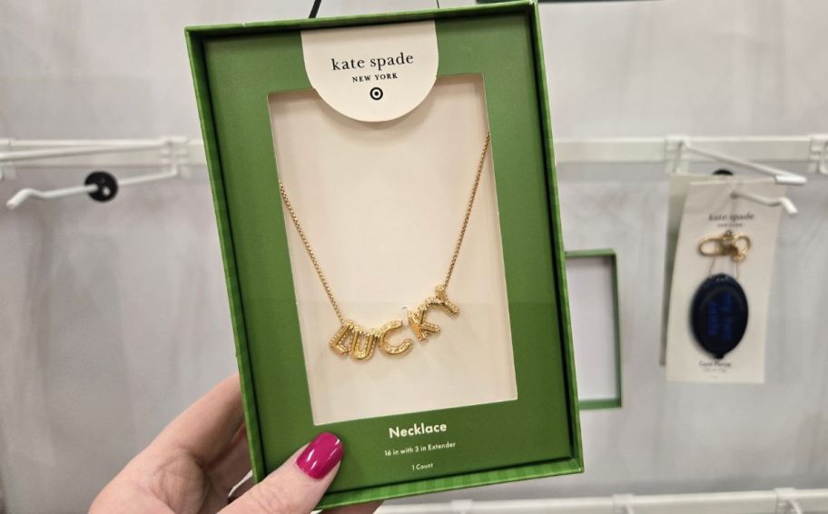 womans hand holding a box with a gold necklace inside
