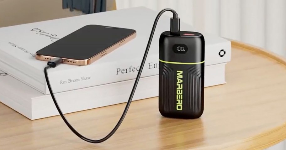 compact power bank charging a phone on a table