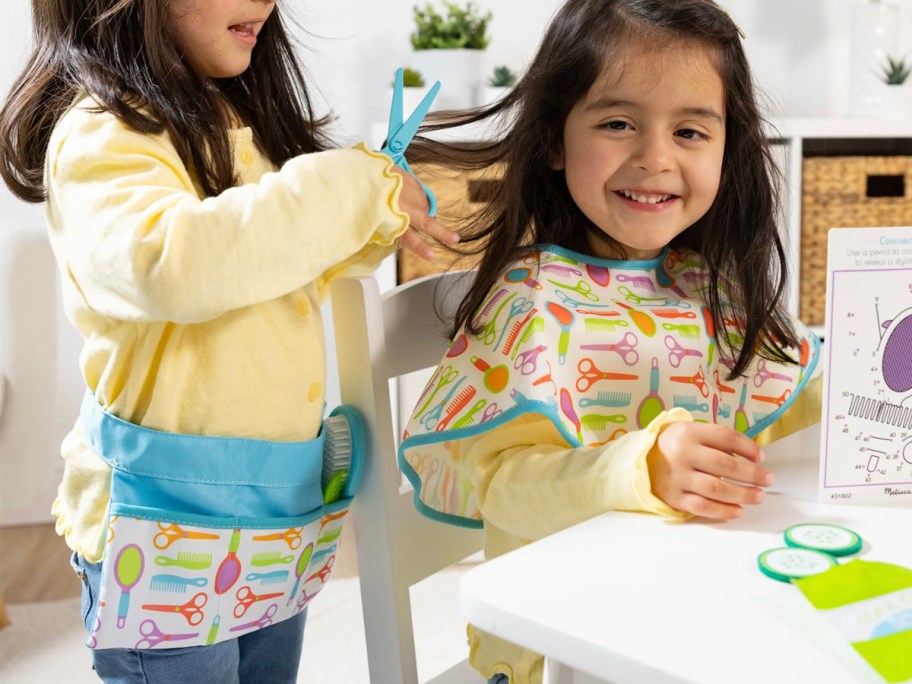 two kids playing with salon playset