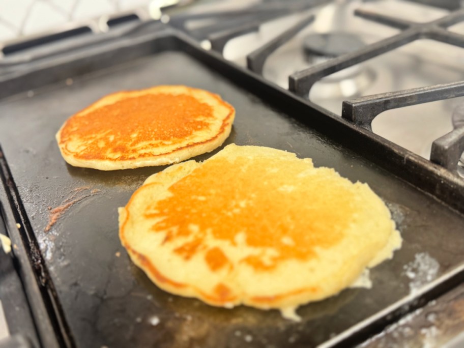 pancakes cooking on a griddle 