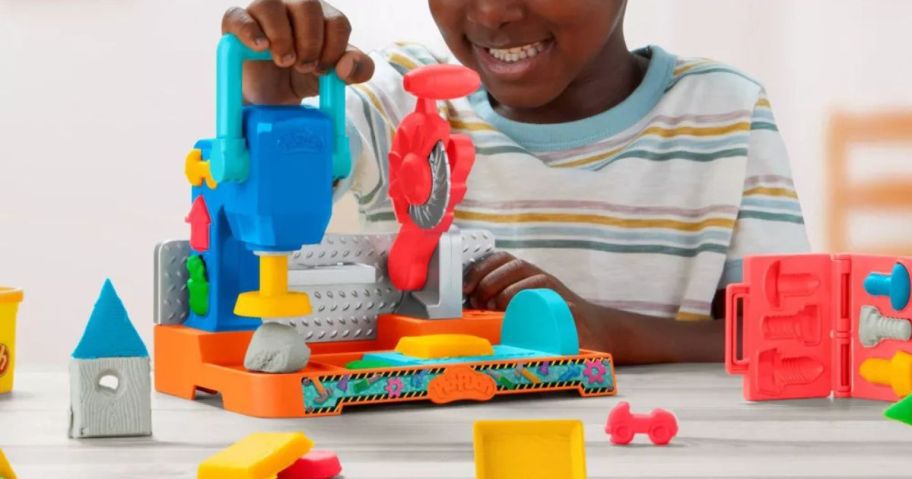 kid playing with Play-Doh Stamp and Saw Tool Bench