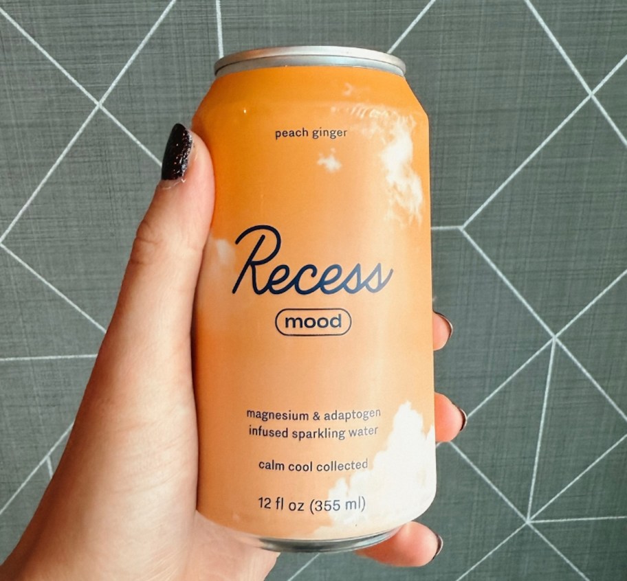 hand holding a can of recess ginger peach