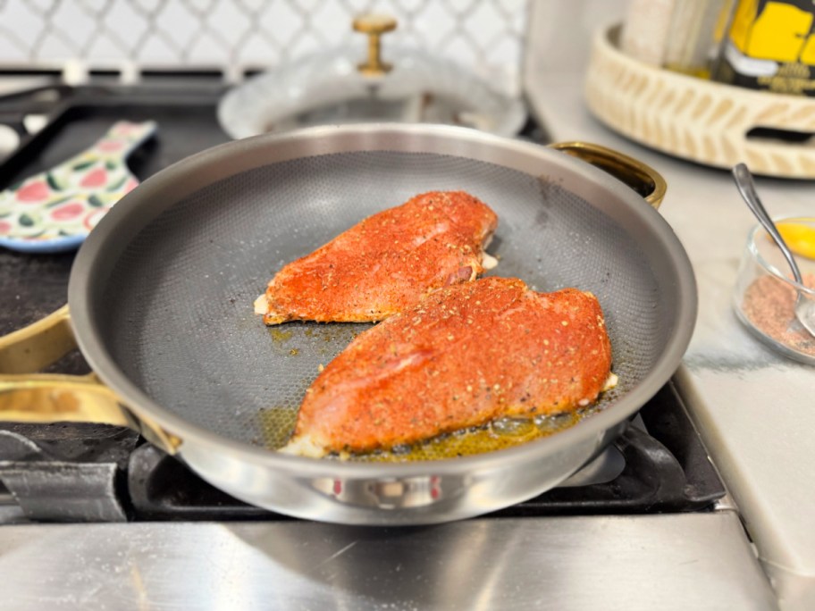seasoned chicken breasts in a hot skillet 