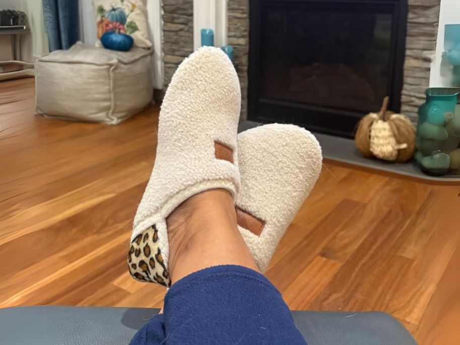 woman wearing cream colored ATHMILE House Slippers with an animal print back with feet