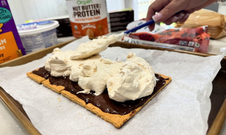 spreading whipped topping mixed with protein powder onto protein smores 