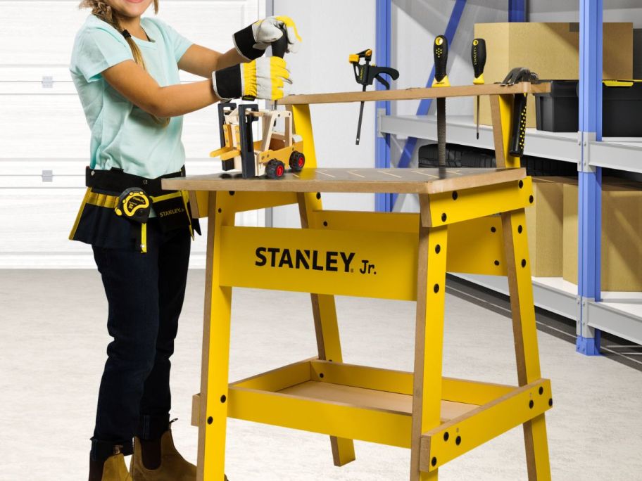 kid using Stanley Jr. Kids Workbench Tool Set & 2 Wooden Kits in garage