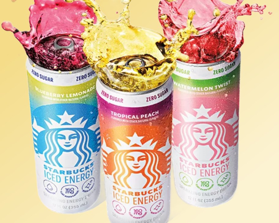three cans of energy drinks with juice spilling out