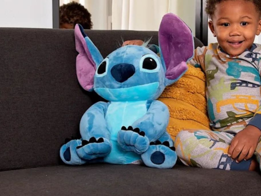 Disney Stitch Plush Pillow Buddy sitting next to child on couch