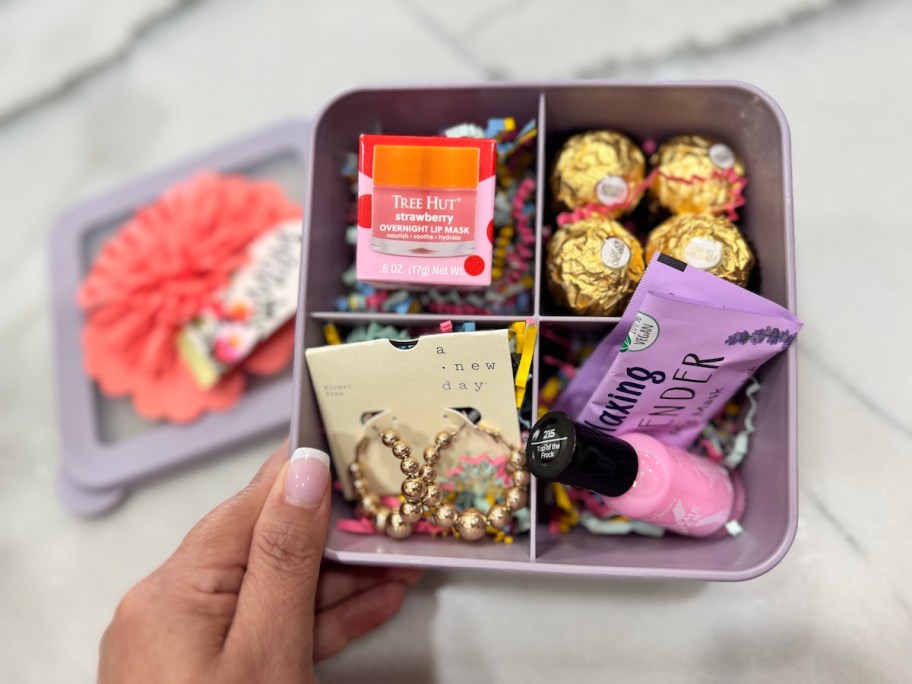 hand holding bento box with goodies inside