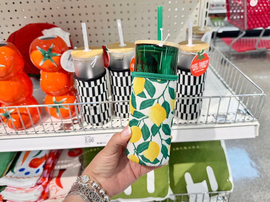 glass tumbler with lemon decorated sleeve in hand in store