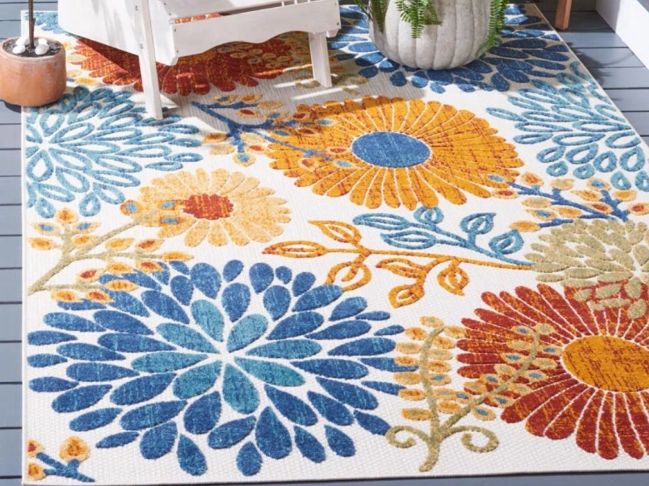 a colorful floral outdoor rug on a patio