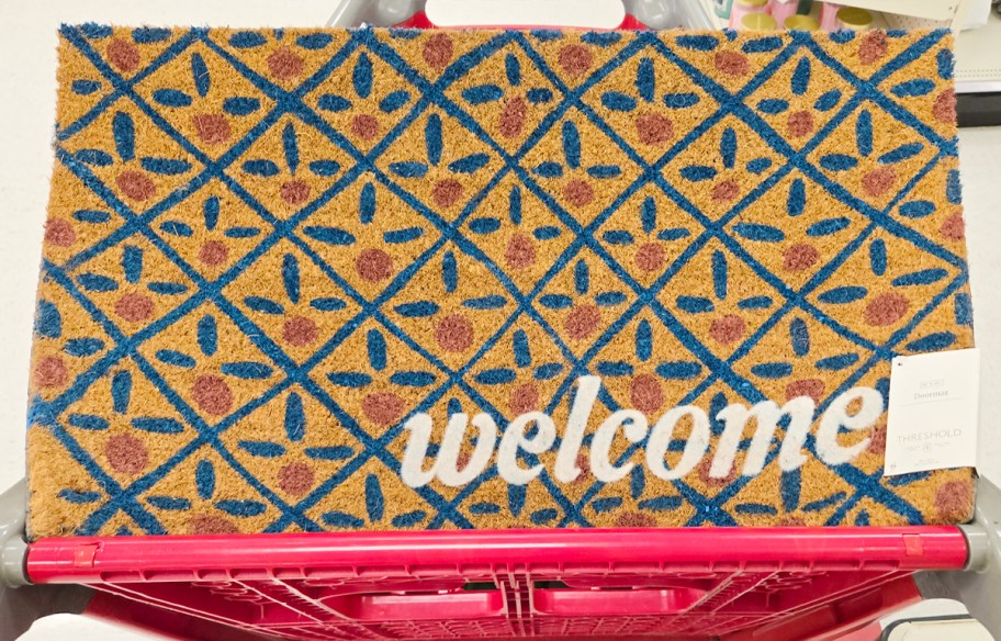 coir doormat that says welcome with blue and red design 