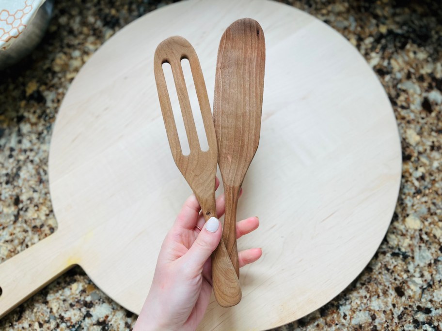 hand holding wood spurtle cooking utensil
