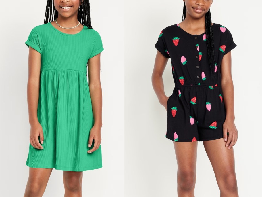 girl wearing a green dress and girl wearing a black romper with strawberries on it