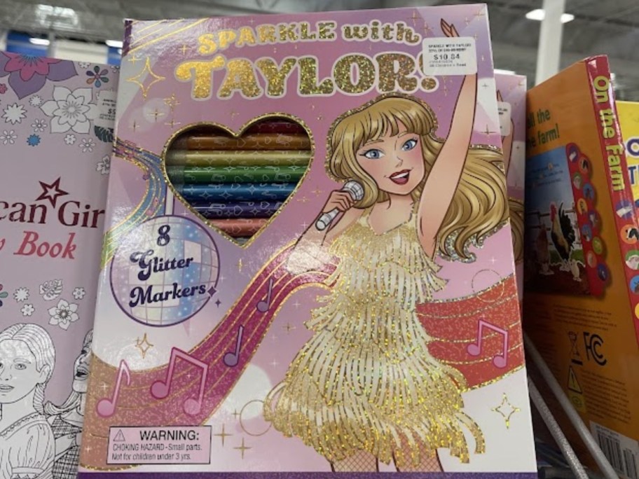 a Taylor Swift coloring book with markers on a store shelf