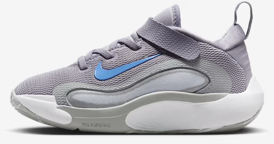 a kids Nike shoe in grey with white and blue accents