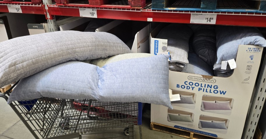 2 cooling body pillows in a Sam's Club shopping cart, a large bin of more in a store aisle behind it