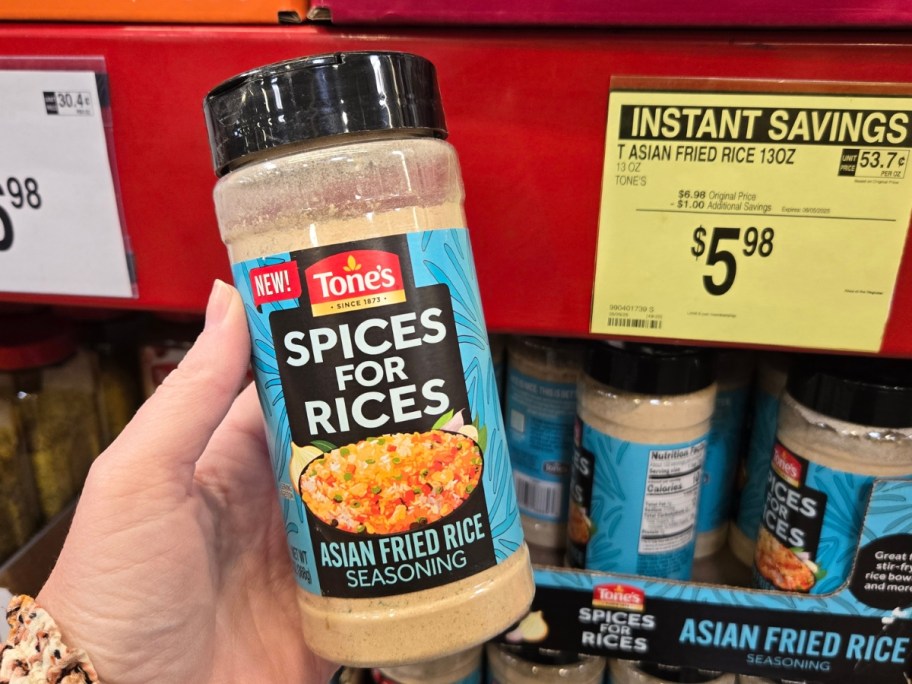 hand holding a container of Tone's Spices for Rices seasoning in a store aisle