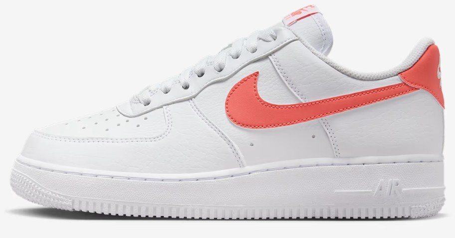 a women's Nike Air Force 1 style shoe in white with orange accents